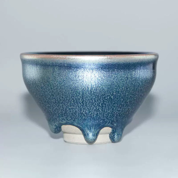 How do tenmoku teacups get their distinctive glaze?